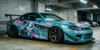 Carro esportivo japonês modificado em estacionamento subterrâneo exibindo arte em vinil de estilo anime fluindo com as linhas aerodinâmicas da carroceria, exemplificando a cultura Itasha de design.